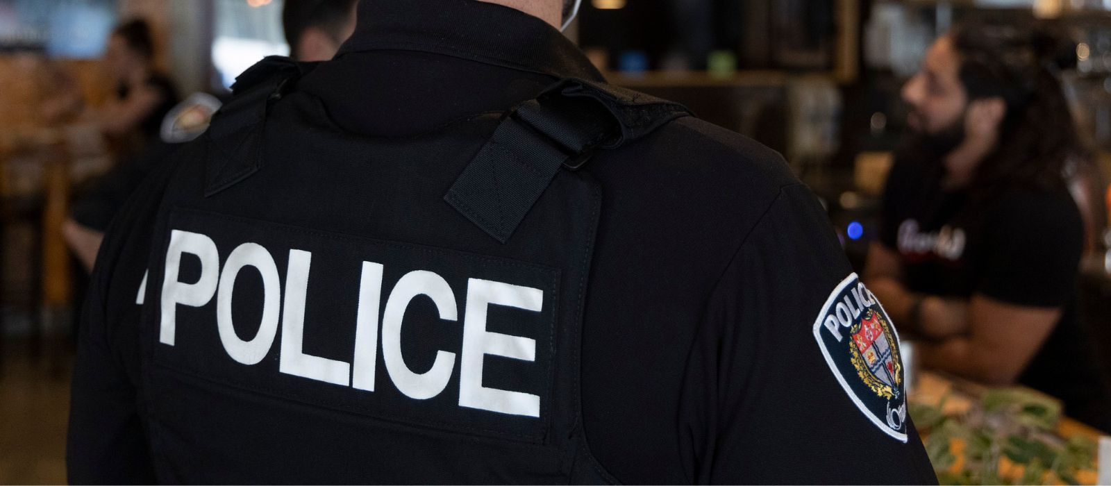 Un agent de la police d'Ottawa converse avec un résident de la communauté dans un restaurant.