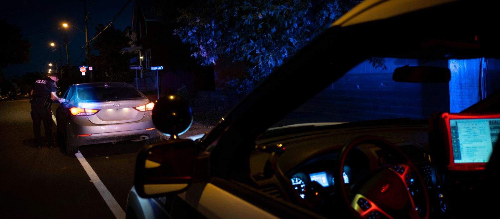 Membre de la police d'Ottawa effectuant un contrôle routier de nuit.
