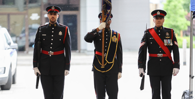 Photo de trois membres de la garde de cérémonie au garde-à-vous
